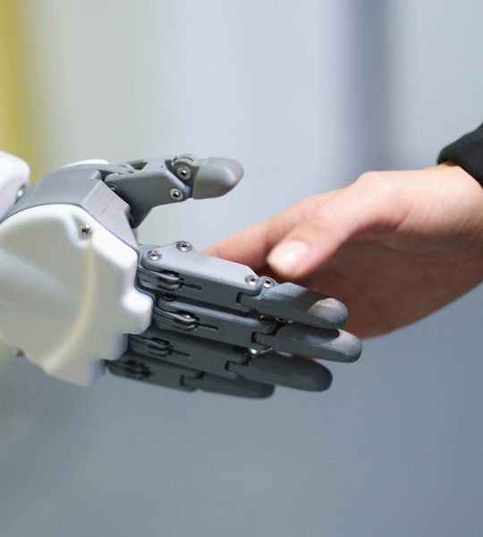 Roboter und Mensch reichen sich die Hände